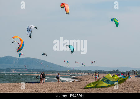 La gente sulla spiaggia praticare kitesurf e prendere il sole, Castelló d'Empúries, Girona, Catalogna, Spagna Foto Stock