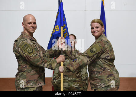 Col. Scott Gibson, 407 Aria Gruppo Expeditionary commander e presiedere officer, presenta il 407 forza expeditionary squadrone di supporto guidon di Lt. Col. Lynn Lightfoot durante un cambiamento di cerimonia di comando in una località segreta nel sud-ovest Asia Luglio 8, 2018. Lt. Col. Michael settimane rinunciato il comando dello squadrone di Lightfoot durante la cerimonia. (U.S. Air Force photo by Staff Sgt. Dana J. cavo) Foto Stock