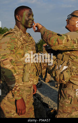 Esercito Pvt. 1. Classe Eric Martinez assegnato al plotone Scout, sede e Sede Società, 2° Battaglione, quinto reggimento di cavalleria, 1° Brigata corazzate contro la squadra, 1° Divisione di cavalleria si applica il camuffamento di fronte alla vernice di esercito Pvt. 1. Classe Jovan cuochi assegnato al plotone Scout, HHC, 2-5 Cav, 1° ABCT, 1 CD a Mihail Kogalniceanu Air Base in Romania, 10 luglio 2018. I soldati condotto un assalto dell'aria esercizio a sostegno di Atlantic risolvere, il permanere di un esercizio di formazione tra la NATO e gli Stati Uniti Le forze. (U.S. Esercito nazionale Guard foto di Spc. Hannah Tarkelly, 382 Affai pubblica Foto Stock