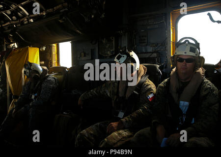 Marina cilena Capt. Jorge Ketiel, centro, un consulente speciale per scopi speciali Air-Ground Marine Task Force - Comando Sud, si affaccia sul retro di un CH-53E Super Stallion elicottero durante un volo alla USS Gunston Hall (LSD 44), 12 luglio 2018. Keitel unisce colombiano di fanteria navale Lt. Col. Erick Del Rio, il vice comandante di SPMAGTF-SC, come la prima nazione partner ufficiali per essere sempre una parte della SPMAGTF-SC personale; il primo passo nella realizzazione di una multinazionale amphibious task force in grado di fornire assistenza umanitaria e di soccorso in caso di catastrofe nella regione. I marines e i marinai di SP Foto Stock