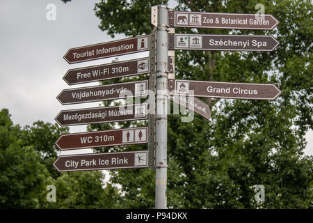 Un segno con più destinazioni vicino a Piazza degli Eroi in Budapest, Ungheria. Foto Stock