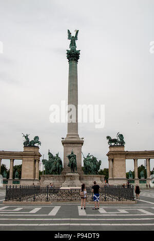 Una vista centrale del millennio monumento in Piazza degli Eroi, Budapest, che mostra la colonna dell Arcangelo Gabriele e le statue della Guerra e Pace su entrambi i lati. Foto Stock