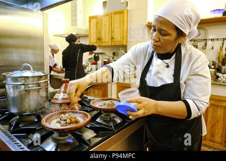 Marrakech, Marocco - Aprile 2016: cuoco donna durante la cottura delle carni bovine marocchino tagine con date e mandorle Foto Stock