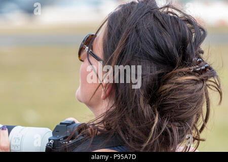 Gloucestershire, UK.14 Luglio, 2018. Attraente giovane donna guardando i battenti visualizza presso il Royal International Air Tattoo, RAF Fairford, Gloucestershire, Regno Unito. RIAT 2018 per celebrare il centesimo anniversario della Royal Air Force con un enorme display aria a RAF Fairford nel Gloucestershire. Forze aeree e volantini arounf da tutto il mondo si riuniscono per fornire incredibile e dislpays areobatics per un enorme folla record di spettatori. . Credito: Steve Hawkins Fotografia/Alamy Live News Foto Stock