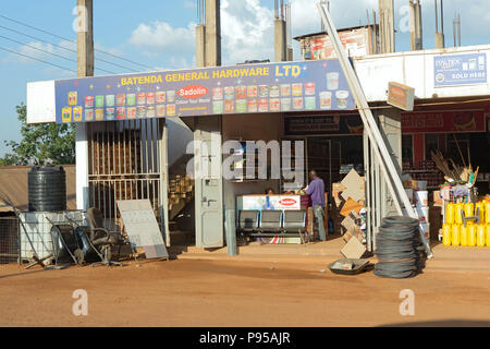 Wakiso Town, Uganda - Scene di strada. Un cliente acquista la vernice in un negozio di ferramenta. Foto Stock