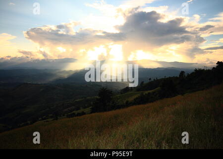 Spettacolari luci di Dio passa attraverso le nuvole e brillante su gamme della montagna. luce calda doccia. Dio la speranza e il concetto di sogno Foto Stock