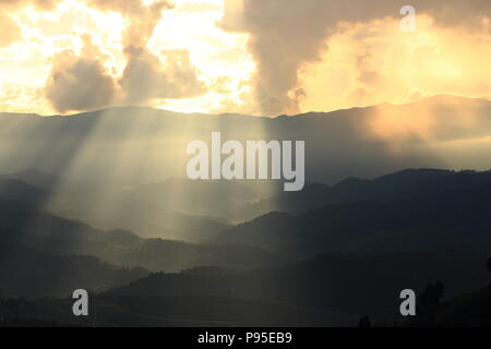 Spettacolari luci di Dio passa attraverso le nuvole e brillante su gamme della montagna. luce calda doccia. Dio la speranza e il concetto di sogno Foto Stock