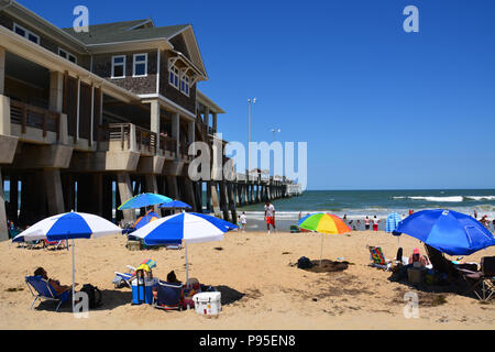 I turisti lay-out sulla spiaggia accanto a Jennette è Pier in Nag testa sul Outer Banks del North Carolina Foto Stock