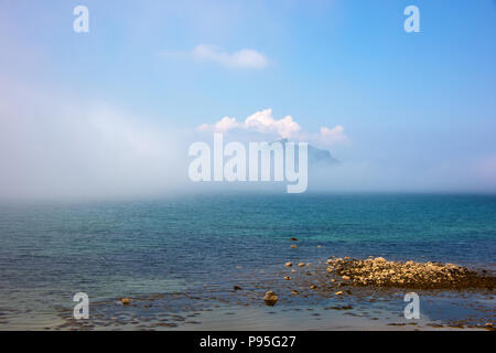 Cresta della collina che si rivelano dietro il cloud oltre il mare dall'Isola di Skye Foto Stock