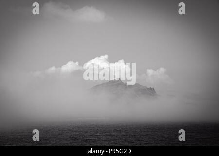 Cresta della collina che si rivelano dietro il cloud oltre il mare dall'Isola di Skye Foto Stock