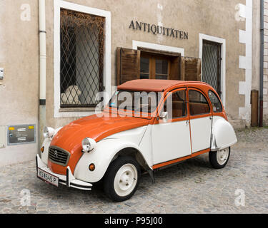 Un classico di Citroën 2CV auto con il colore arancione e bianco al di sotto del rivestimento di un negozio di antiquariato di firmare in Stein an der Donau, Austria inferiore Foto Stock