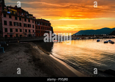 Un bel golden arancione tramonto oltre al porticciolo di Vernazza, Italia, parte delle Cinque Terre. Foto Stock