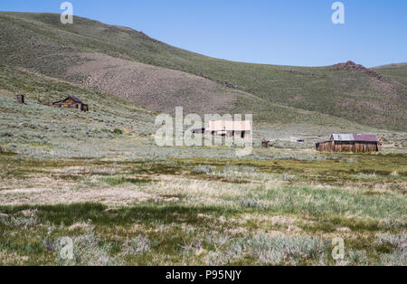 Abitazioni abbandonate nella distanza nella città fantasma di Bodie, California, una città mineraria dal Vecchio West. Foto Stock