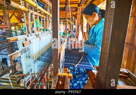 Lago Inle, MYANMAR - 18 febbraio 2018: la produzione di tessili in seta sulla tradizionale vecchio telaio a mano in officina, situato sul Lago Inle in Inpawkhon vil Foto Stock