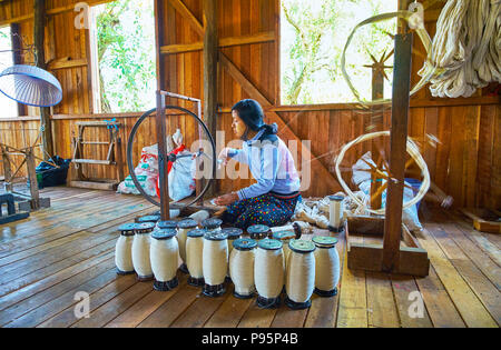 INPAWKHON, MYANMAR - 18 febbraio 2018: gli steli con filato di fronte al lavoratore di sesso femminile che di tessitura a mano workshop, il 18 febbraio in Inpawkhon. Foto Stock