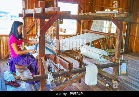 INPAWKHON, MYANMAR - 18 febbraio 2018: la produzione del cotone, seta e tessuti lotus sul lato telaio in officina, situato nel villaggio di Inpawkhon su Inle Foto Stock