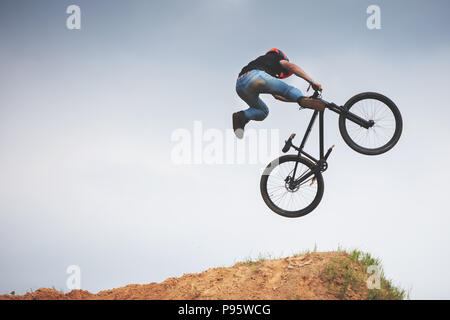 Mtb dirt rider facendo trick su un salto Foto Stock