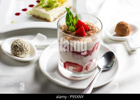 Tabella dolce con organici cibo crudo dessert, dolci, yogurt con fragole e torta Foto Stock