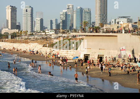 Bella Jaffa e Alma spiagge affollate di gente con Tel Aviv skyline in background Foto Stock