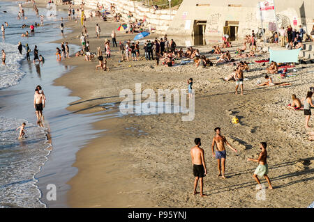 Bella Jaffa e Alma spiagge affollate di gente con Tel Aviv skyline in background Foto Stock