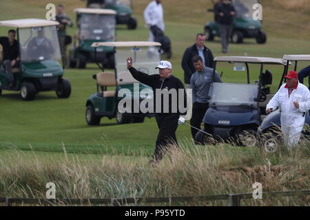 Il presidente statunitense Donald Trump (centro) sul suo campo da golf al Trump Turnberry Resort in South Ayrshire, dove lui e sua moglie Melania, trascorso il weekend come parte della loro visita nel Regno Unito prima di partire per la Finlandia dove incontrerà leader russo Vladimir Putin per colloqui il lunedì. Foto Stock