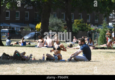 Persone sole in Haggerston Park, a Hackney est di Londra come il clima caldo prosegue attraverso la maggior parte delle parti del Regno Unito. Foto Stock