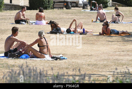 Persone sole in Haggerston Park, a Hackney est di Londra come il clima caldo prosegue attraverso la maggior parte delle parti del Regno Unito. Foto Stock