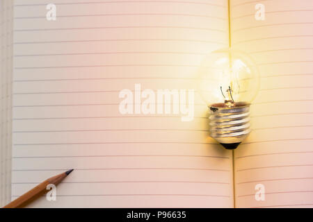 Concetto idea. In crescita la lampadina luce sul libro vintage con matita. Copia dello spazio per il tuo testo grande concettuale idee sono sempre disponibili. Il pensiero creativo Foto Stock