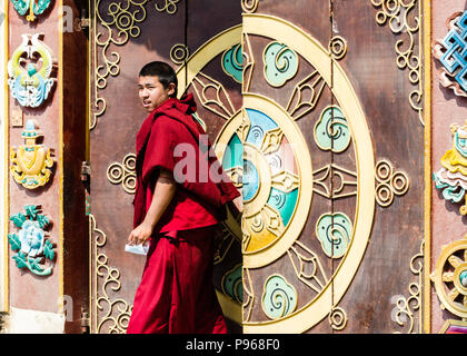 Monaco buddista presso la porta di Drubgon Jangchup Choeling Gompa, un Buddismo tibetano monastero accanto a Kathesimbhu Stupa, Kathmandu, Nepal Foto Stock