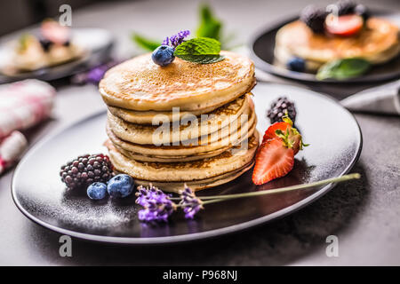 Pancake con fragole mirtilli more di lavanda e foglie di menta. Foto Stock