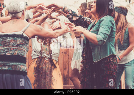 Gruppo di libera e ribelle hippy stile alternativo di donne giovani insieme per ballare e celebrare con gioia e felicità in un luogo naturale indoor e outd Foto Stock