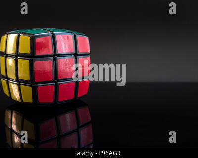 Round il cubo di Rubik su sfondo nero con la riflessione della luce in studio Foto Stock