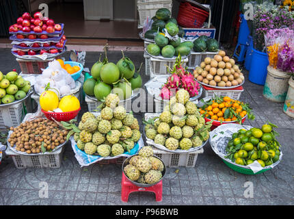 Varietà di frutta sul display sul marciapiede davanti a un negozio di alimentari a Ho Chi Minh City, Vietnam. Foto Stock
