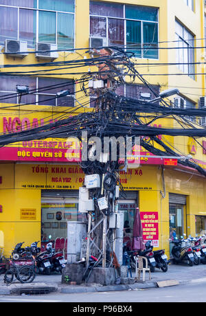 Polo di alimentazione aggrovigliato con linee elettriche di alimentazione e i cavi di telefono nella città di Ho Chi Minh, Vietnam. Foto Stock