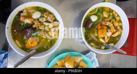 Bocce di banh canh cua, un granchio noodle soup, servita in un ristorante in città di Ho Chi Minh, Vietnam. Foto Stock