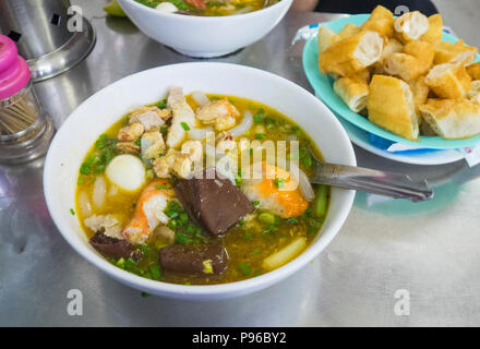 Bocce di banh canh cua, un granchio noodle soup, servita in un ristorante in città di Ho Chi Minh, Vietnam. Foto Stock