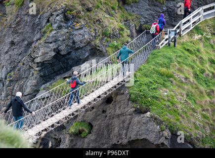 I turisti a piedi su di Carrick-a-Rede ponte di corde sulla costa Causeway nella contea di Antrim, Irlanda del Nord Foto Stock