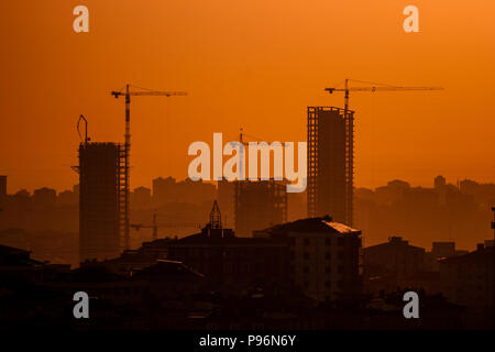 Industrial gru per edilizia e costruzione di sagome al tramonto Foto Stock