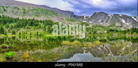 Uno da sette più pulito di montagna laghi Karakol, situato nella valle ai piedi del Bagatash pass, montagne di Altai, Russia. Cime coperte di neve a Foto Stock