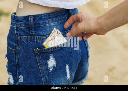 Rubare la valuta da tasca dei jeans in mancanza di consapevolezza Foto Stock