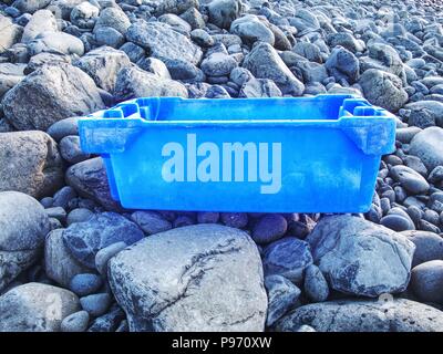 Plastica e spazzatura gommoso lavato fino a una spiaggia sassosa. Fotografia che mostra il problema dell'inquinamento. Rifiuti pericolosi espulso dal mare sulle spiagge remote. Foto Stock