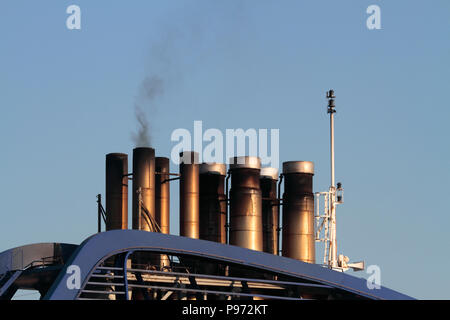 Fumaioli su una nave da crociera emettendo fumo mentre nel porto. Navi bruciare olio combustibile pesante danno luogo ad un significativo inquinamento atmosferico in aree portuali Foto Stock