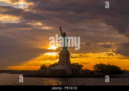 Bellissima la luce del tramonto illumina la Statua della Libertà nel porto di New York Foto Stock