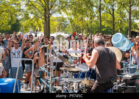 Berlino, Germania - Luglio 2018: molte persone nelle affollate Park (Mauerpark) guardando street esecuzione / musicista suonando la batteria su una soleggiata domenica di estate Foto Stock