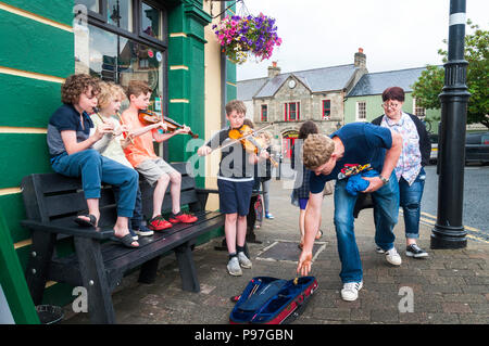 Ardara, County Donegal, Irlanda. Il 15 luglio 2018. Giovani musicisti a mantenere le tradizioni in strada al di fuori di un bar in Irlanda del nord-ovest. La musica tradizionale irlandese è una lunga storia qui. Credito: Richard Wayman/Alamy Live News Foto Stock