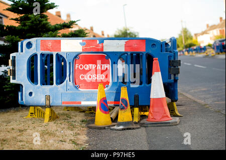 Birmingham, Regno Unito. 15 luglio 2018. Barriere in plastica blu con il cartello "footpath closed" in posizione sul marciapiede, mentre i vecchi tubi di gas di ferro vengono sostituiti con tubi in plastica gialla più resistenti a Birmingham, domenica 15 luglio 2018. Cadent, precedentemente noto come National Grid gas Distribution, sta effettuando la manutenzione del gas essenziale in strada. Gli automobilisti sono stati avvertiti di aspettarsi ritardi e di trovare un percorso alternativo, se possibile. Credit: NexusPix/Alamy Live News Foto Stock