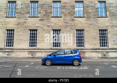 Auto blu parcheggiate nel parcheggio disabili bay Foto Stock