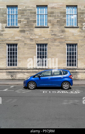 Auto blu parcheggiate nel parcheggio disabili bay Foto Stock