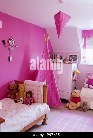 Rosa fucsia wigwam e parete in camera bambino con teddybears e torace bianco-di-cassetti Foto Stock