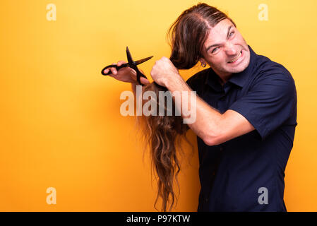 Crazy angry man il taglio di capelli con le forbici Foto Stock